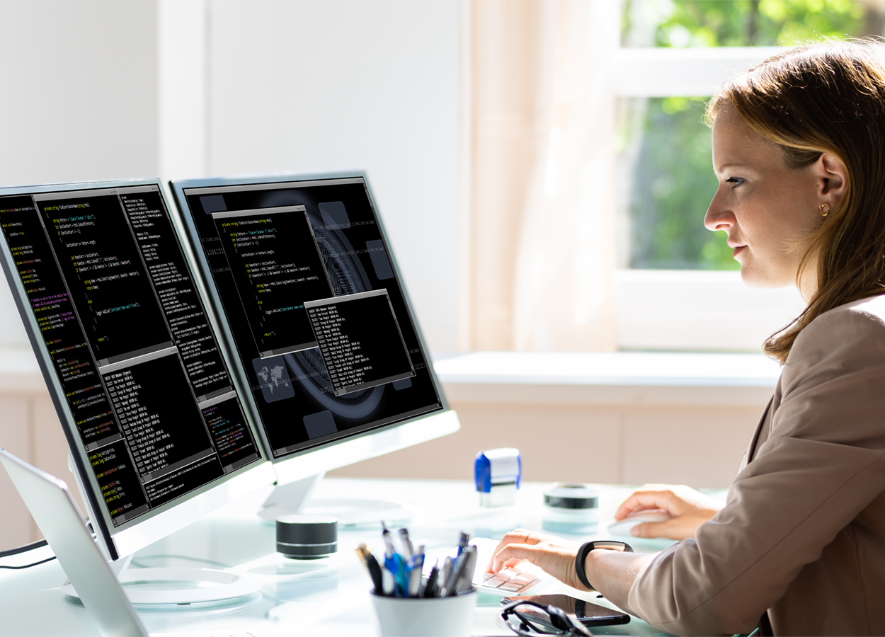 Programmer sitting down programming on their laptop.