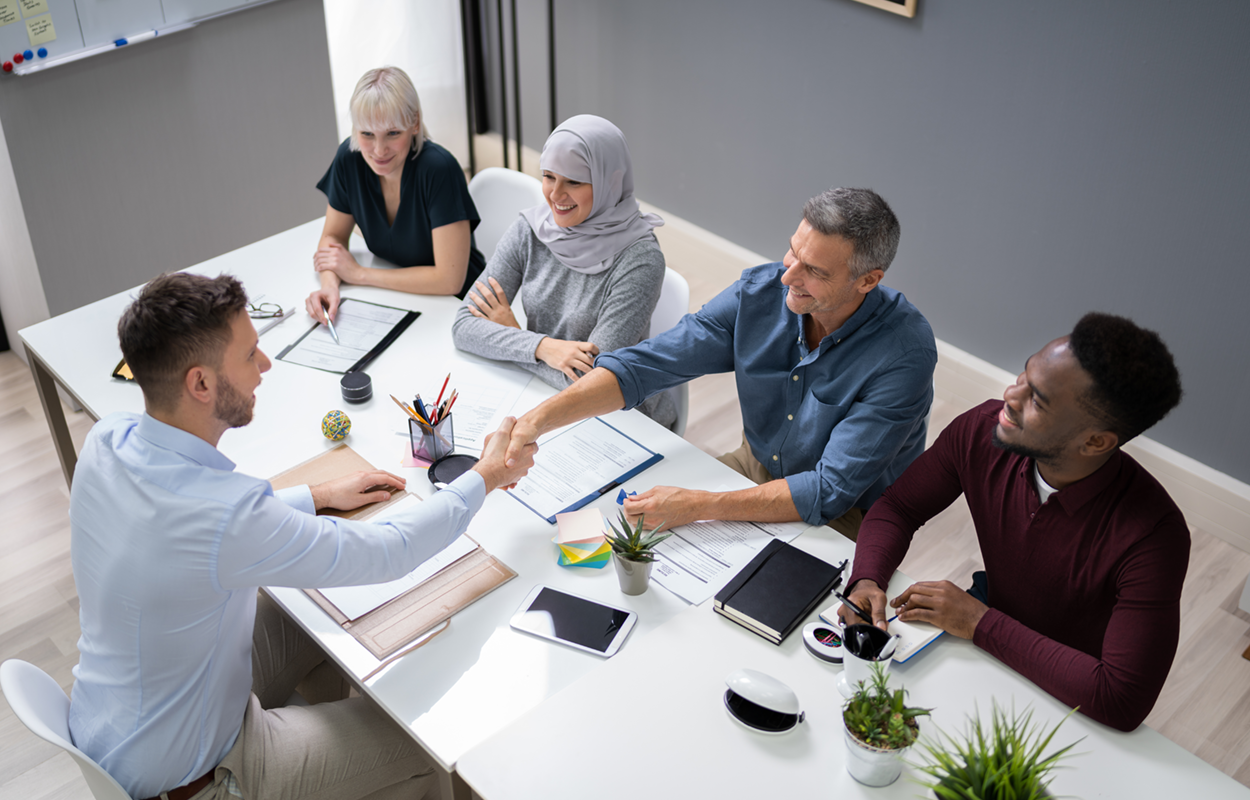 a table with multiple people interviewing one individual in person