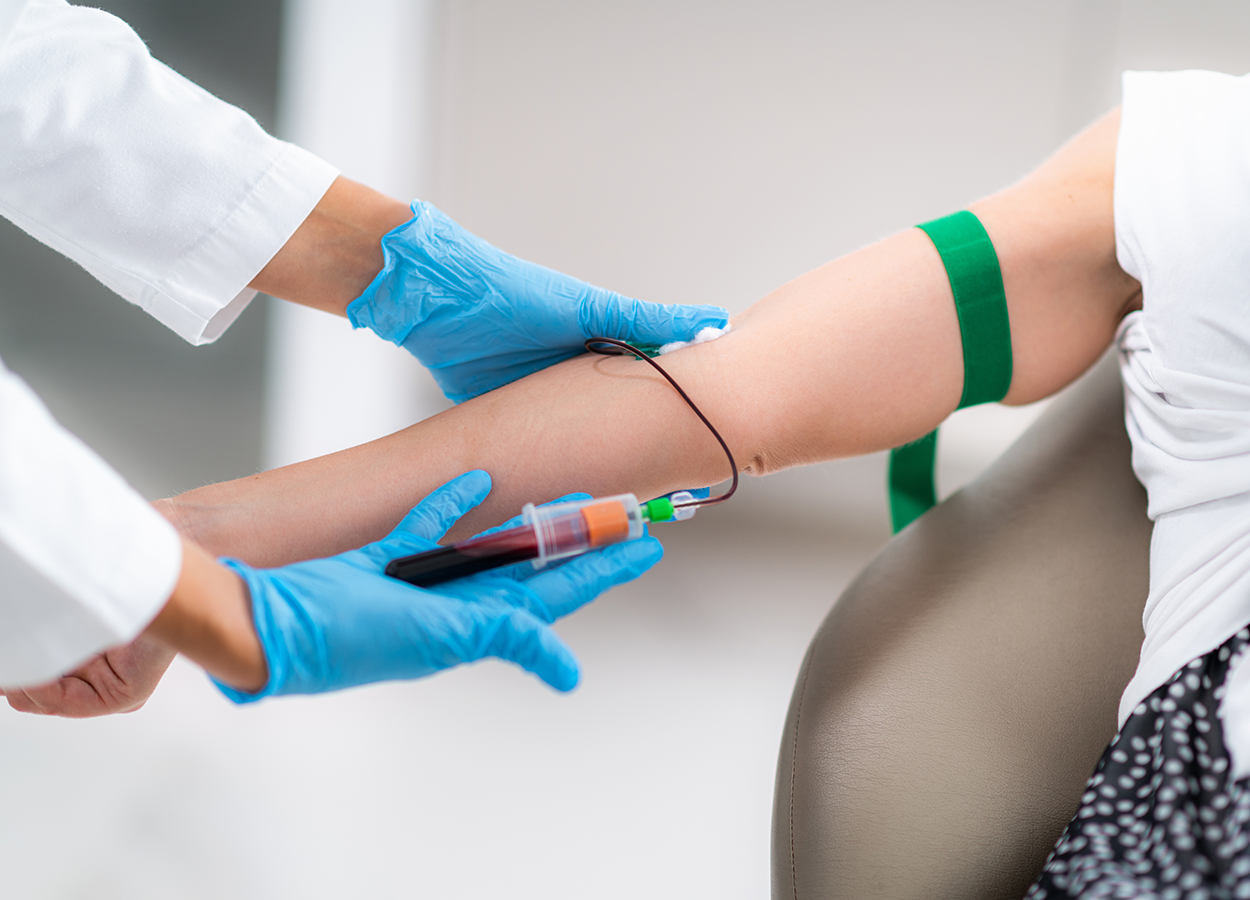 A patient getting blood drawn from their inner elbow into a test tube.