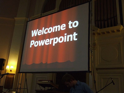 A presentation screen is shown with a PowerPoint slide that says 'welcome to Powerpoint' on it.