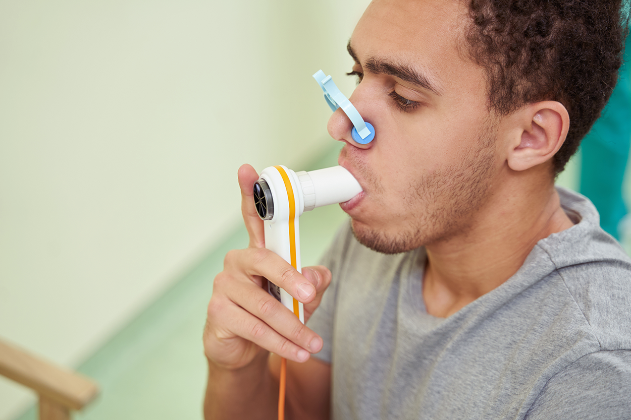 A Patient Checking His Lung Function with a Spirometer