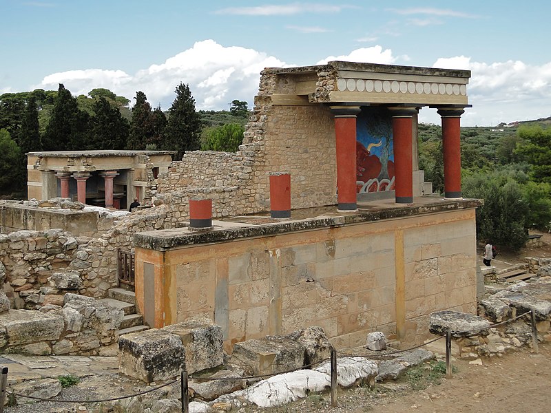 building where the left side is ruins and the right has the remains of a secondary porch with red columns