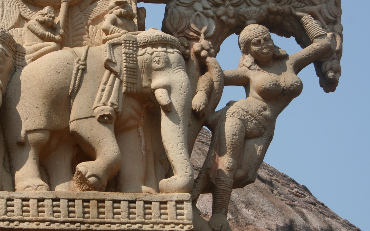 stone sculpture detail of a woman holding up branches of a tree next to two elephants