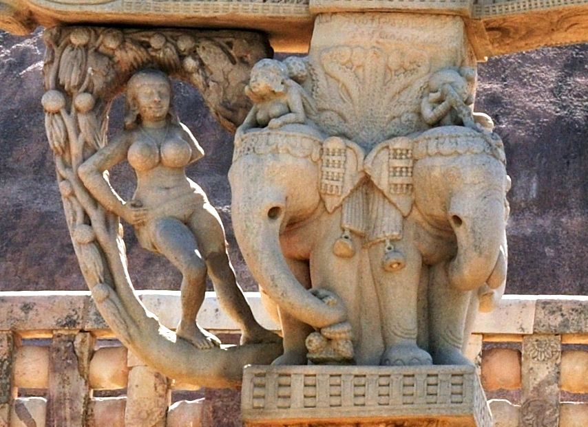 stone sculpture detail of a woman leaning against tree next to two elephants