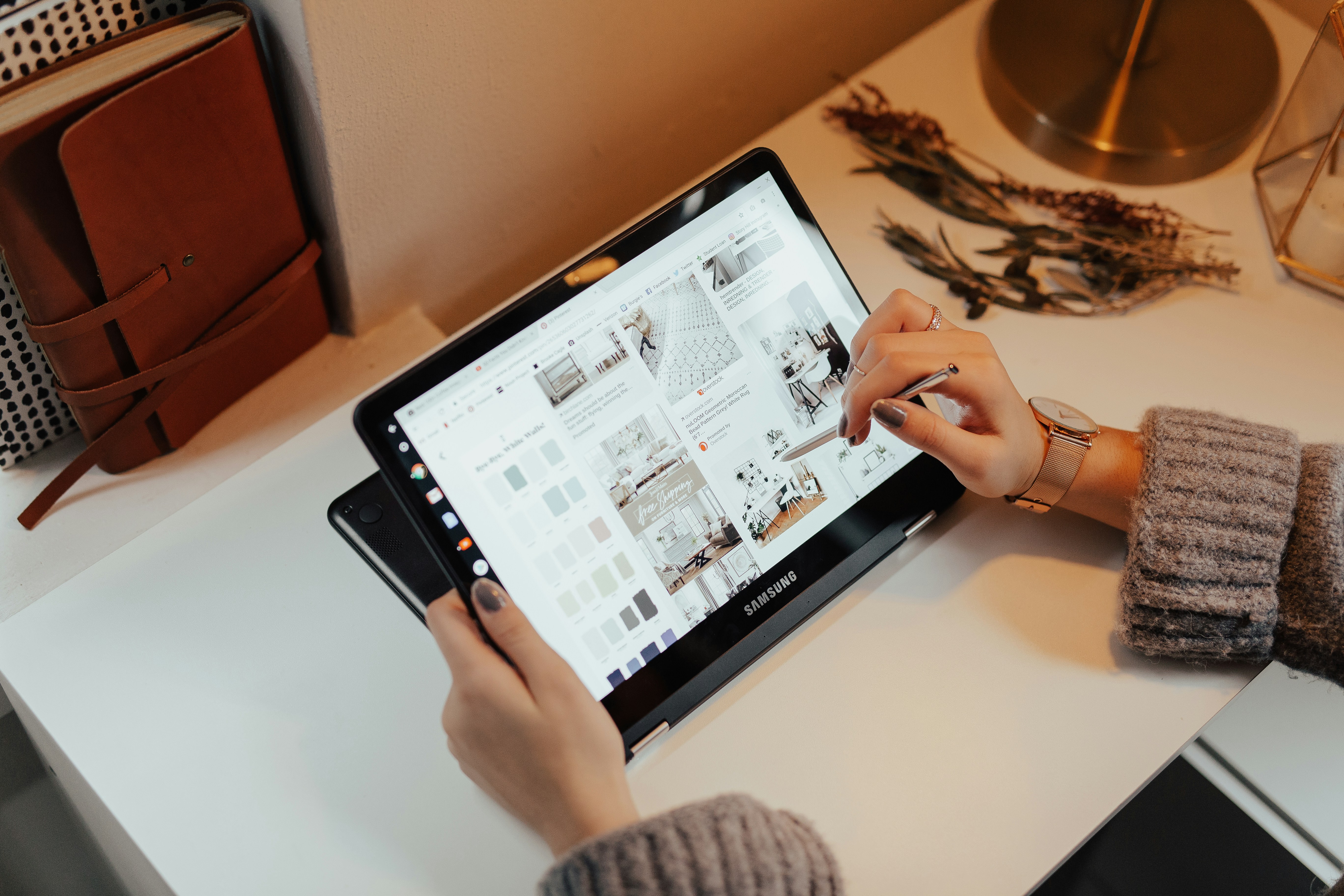 a person using a stylus on a tablet computer to purchase home furnishings online