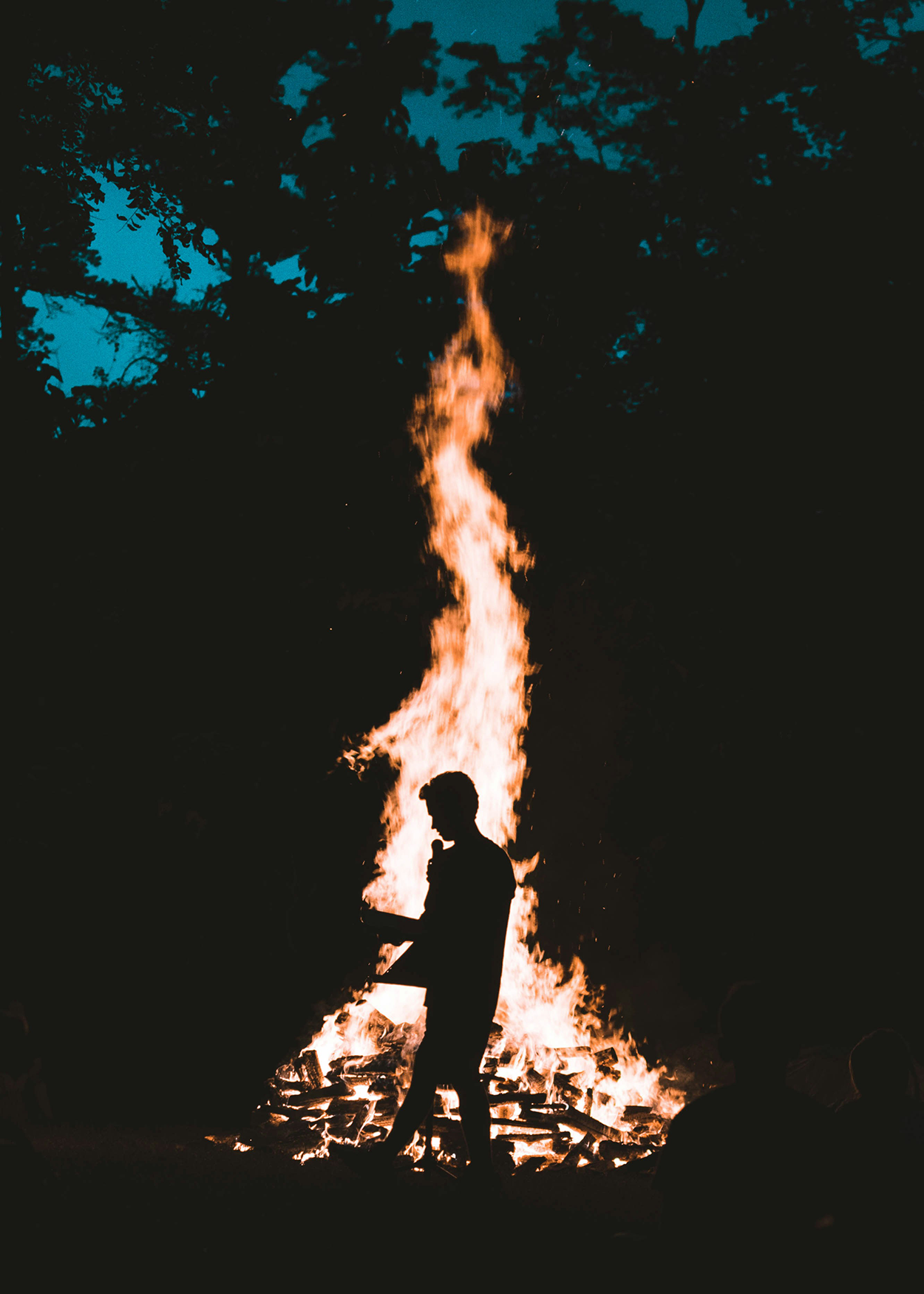 A man standing in front of a bonfire