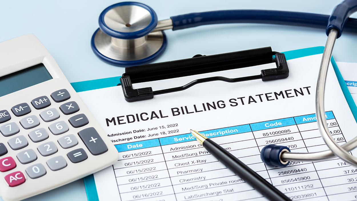 The image shows a close-up of a medical billing statement placed on a clipboard. The document includes itemized charges for various medical services with columns for dates, descriptions, codes, and amounts. A pen rests on the paper, indicating a review or payment process. Surrounding the statement are a calculator, a stethoscope, and a clipboard, symbolizing financial planning and health-care costs. The setting suggests a focus on managing medical expenses, insurance claims, or billing inquiries.