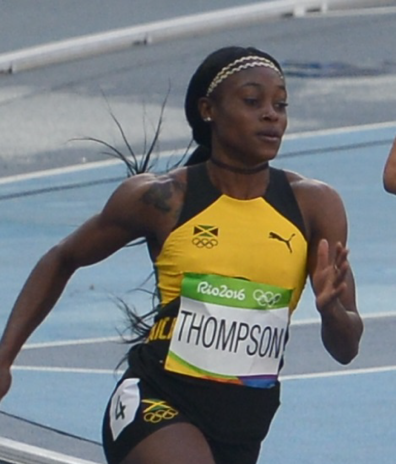A Jamaican woman sprints with strong muscles, and a calm, determined look while competing in the 2016 Olympics.
