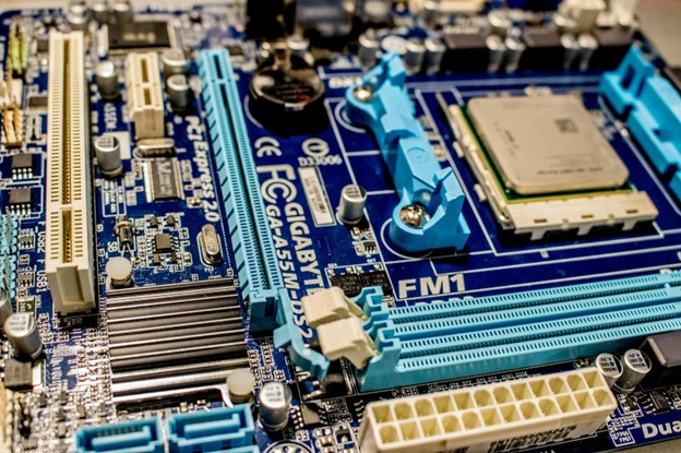 A motherboard consisting of a CPU, RAM slots, capacitors, integrated chips, and a battery